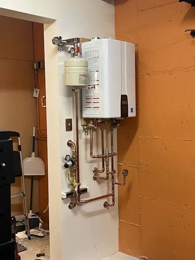 Plumbing technician inspecting water heater connections in West Odessa